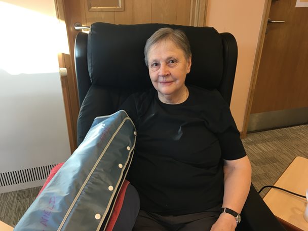 Photo of Ann who is a patient at Barnsley Hospice. Ann is seated in a chair and her arm has a cover on it.