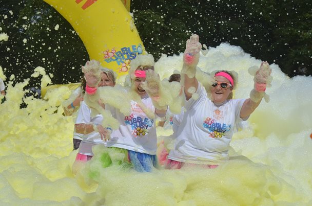 Photo of a group of ladies running through foam.