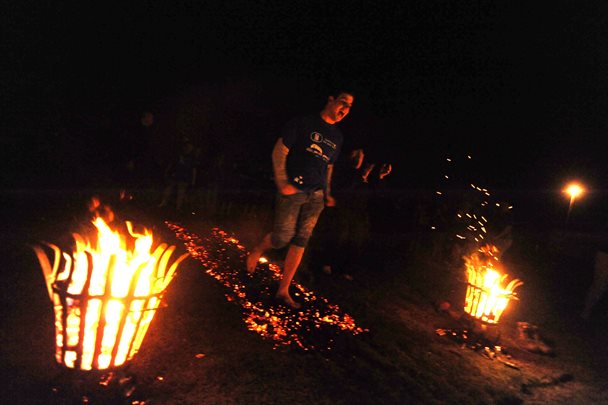 Photo of a man walking on hot Coles in the dark