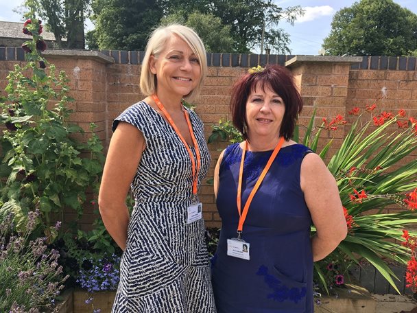 A photo of two ladies standing outside in the Barnsley Hospice garden.