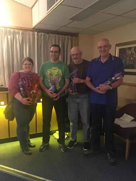 Photo of four participants at the Yorkshire Bank quiz night. The group are holding the prizes they have won.