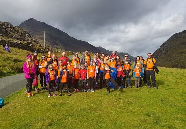 Photo of the children from the School of Walk club standing in the countryside with mountain peaks in the background.