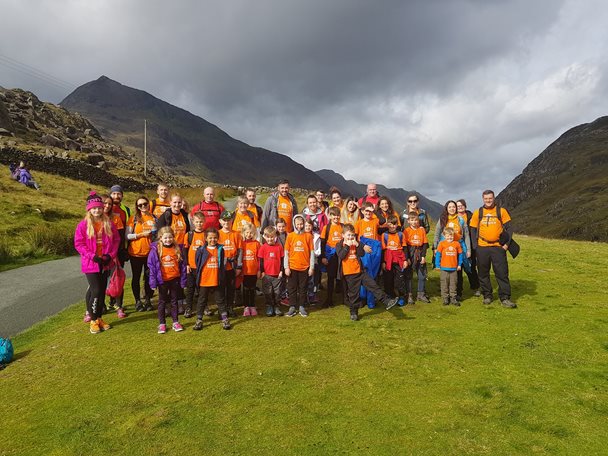 Photo of the children from the School of Walk club standing in the countryside with mountain peaks in the background.