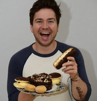 Photo of Sam Nixon holding a plate of cakes