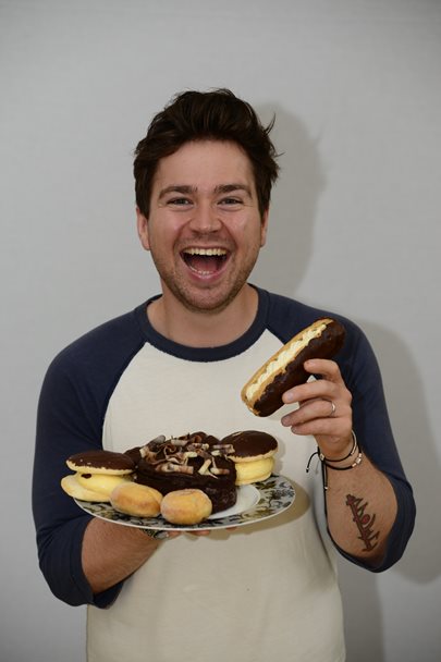 Photo of Sam Nixon holding a plate of cakes