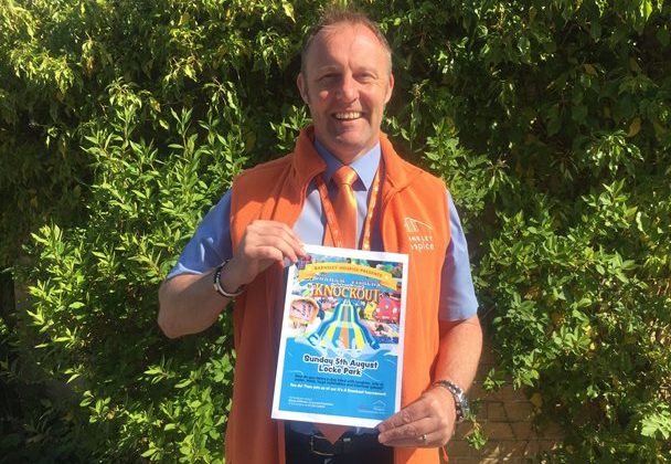 Photo of Simon Atkinson holding a leaflet advertising an It's a Knockout event.