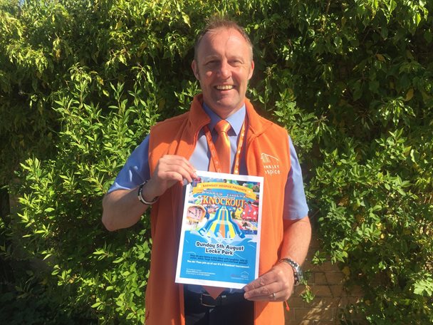Photo of Simon Atkinson holding a leaflet advertising an It's a Knockout event.