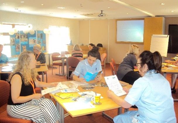 Photo of Barnsley Hospice staff seated at desks and reading documents as part of a training event