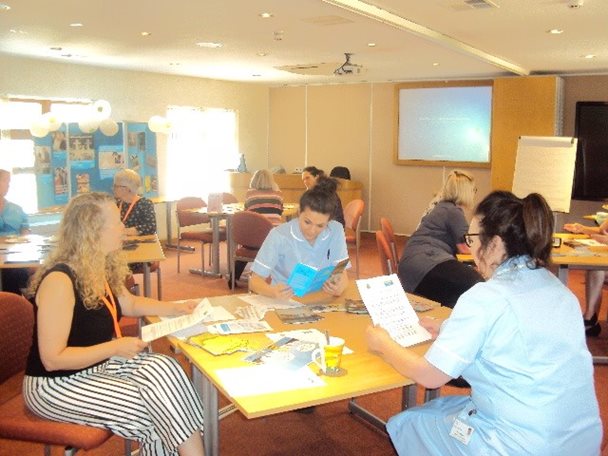 Photo of Barnsley Hospice staff seated at desks and reading documents as part of a training event