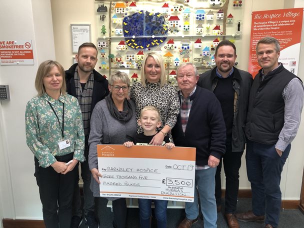 Photo a family group presenting Barnsley Hospice with a donation cheque.