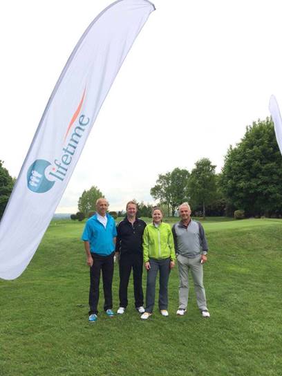 Photo from the Barnsley Hospice golf day. Four people are standing on the golf course.