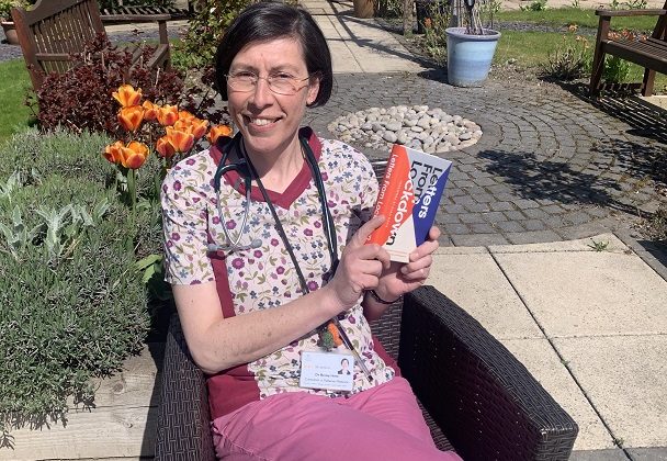 Photo of Dr Becky Hirst holding the book; Letters from Lockdown.