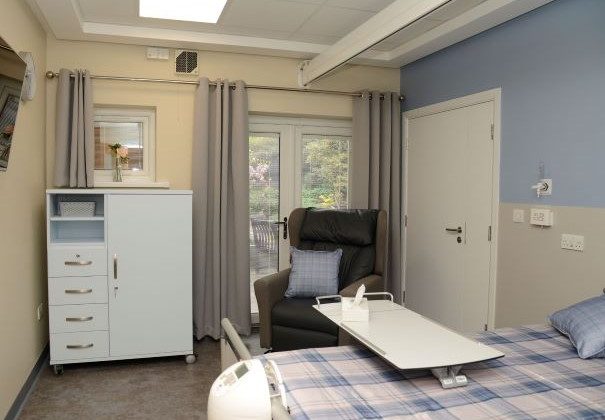 Photo of an inpatient room showing the bed, chair and storage cupboard