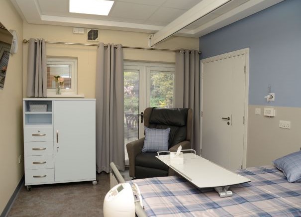 Photo of an inpatient room showing the bed, chair and storage cupboard