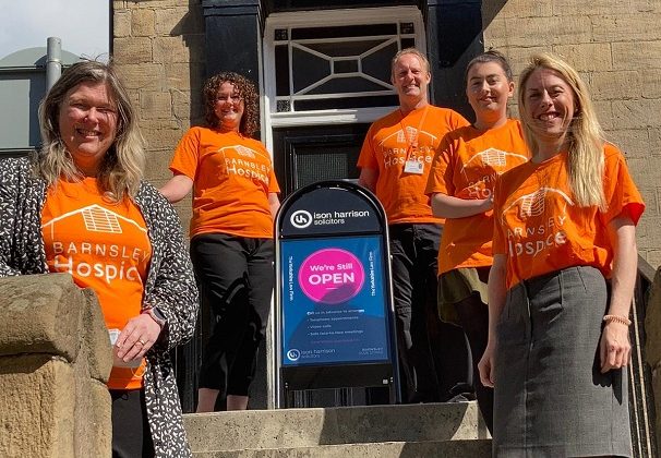 Photo of the team from Ison Harrison standing outside their offices. They are all wearing orange coloured Barnsley Hospice t-shirts.