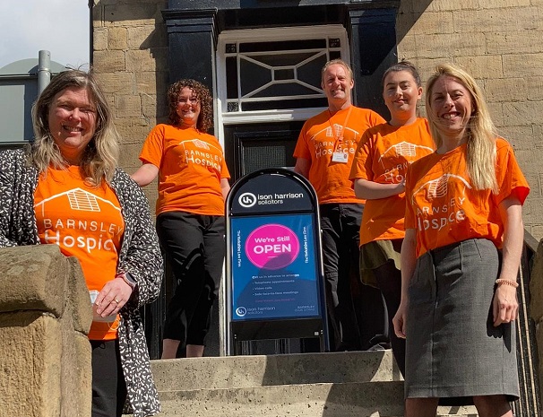 Photo of the team from Ison Harrison standing outside their offices. They are all wearing orange coloured Barnsley Hospice t-shirts.