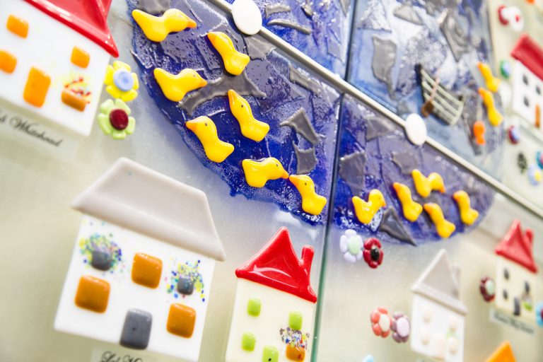 A close up photo of a the Hospice's glass memory village wall art
