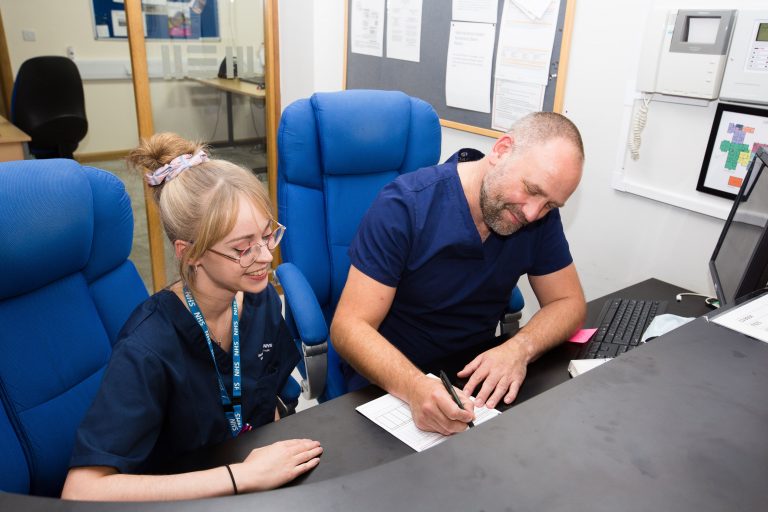 Photo of two members of the Barnsley Hospice completing forms on a desk