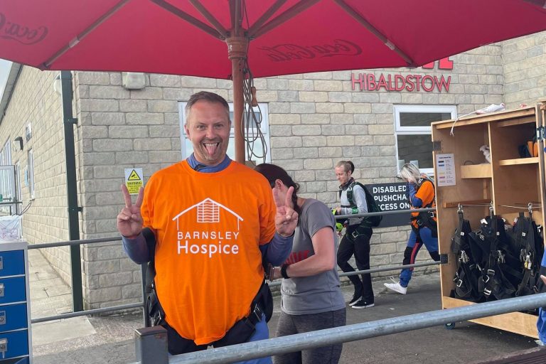 Photo of a man wearing a Barnsley Hospice t-shirt, smiling.