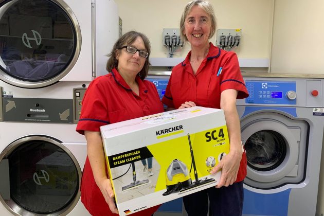 Photo of Lorraine and Tracey holding a steam cleaner purchased from the Amazon Wishlist by a supporter of the Hospice