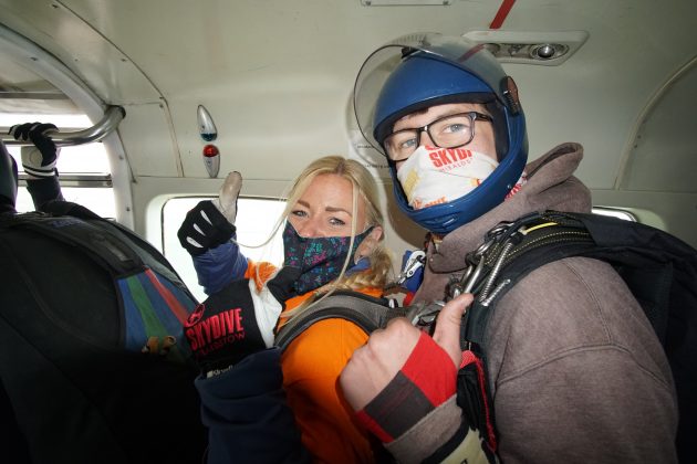 Photo of Naomi in an aeroplane doing a thumbs up sign just before doing her tandem skydive