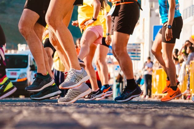 Photo of a group of people from the waist downwards wearing shorts and trainers ready to participate in the Great North Run.