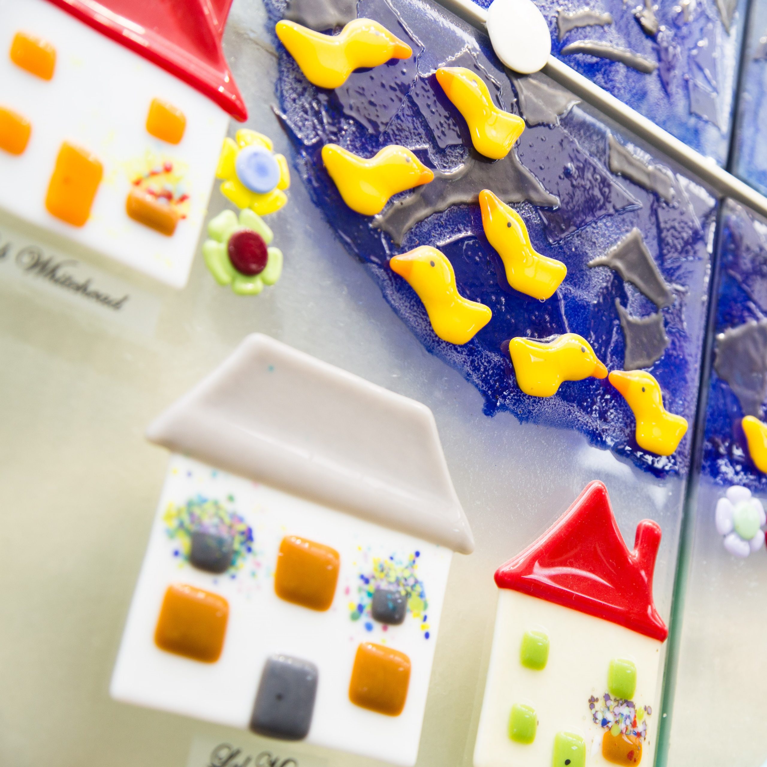 A close up photo of a the Hospice's glass memory village wall art