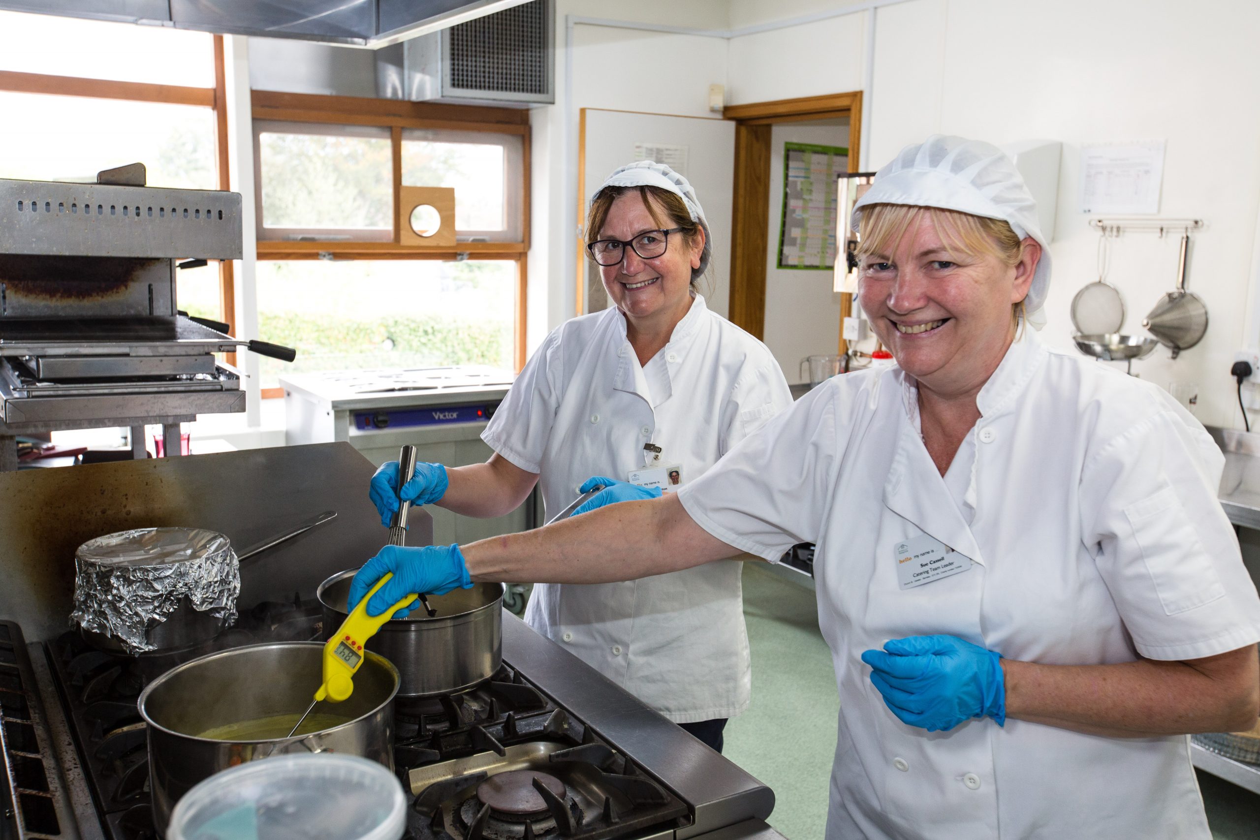 Photo of two of the Barnsley Hospice catering team working in the kitchen