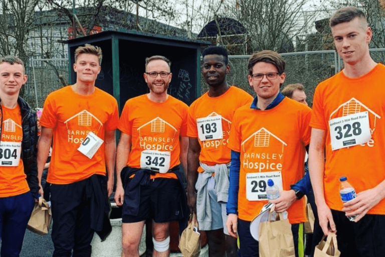 A photo of the team from NPS wearing orange hospice t-shirts for the fun run