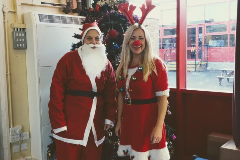 A photo of two people dressed in Christmas outfits for the Rudolph fun run event