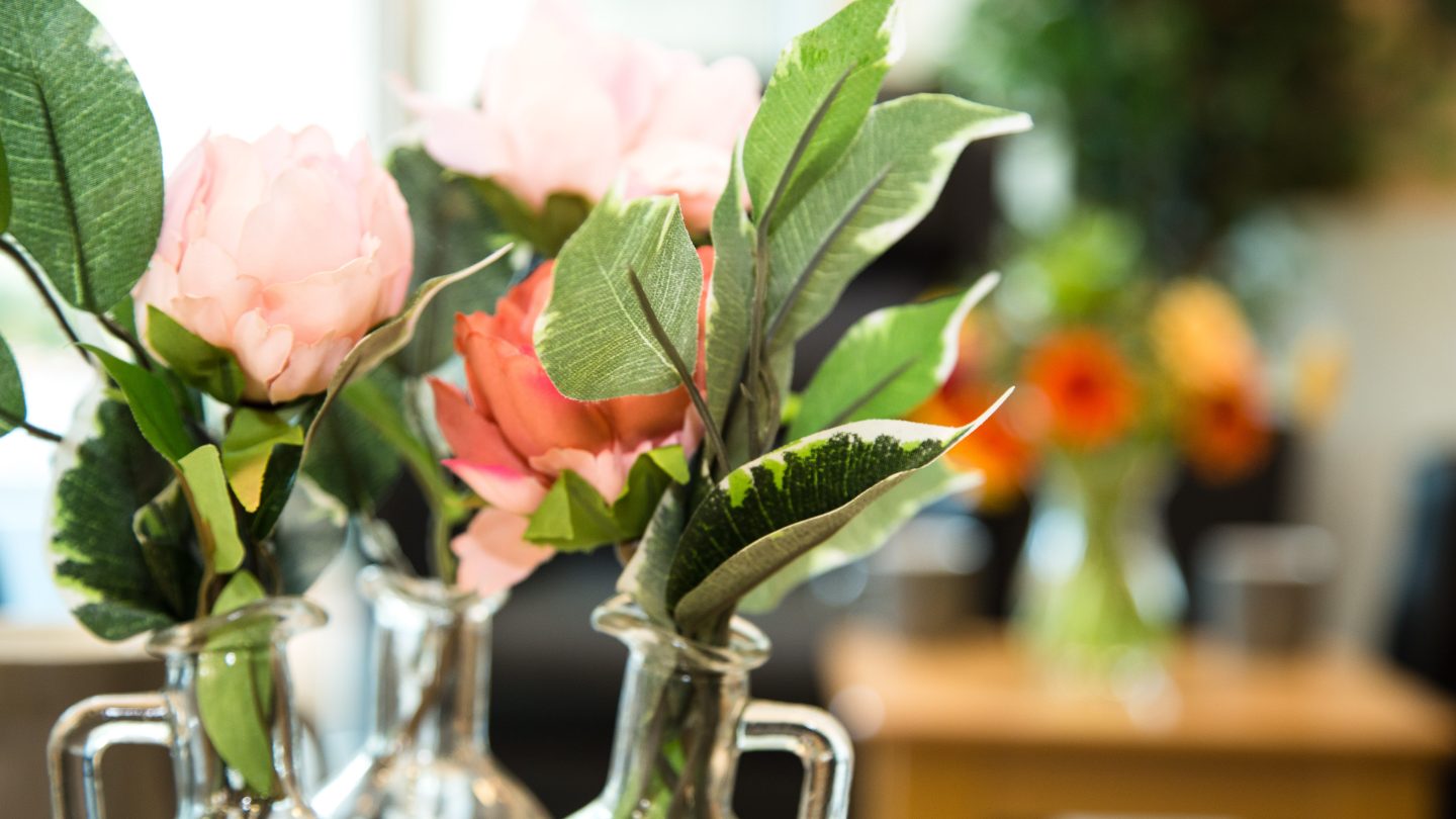 Orange flowers and green foliage in a vase.