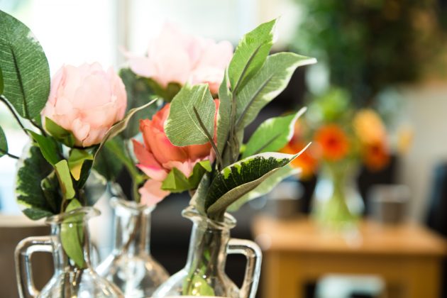 Orange flowers and green foliage in a vase.