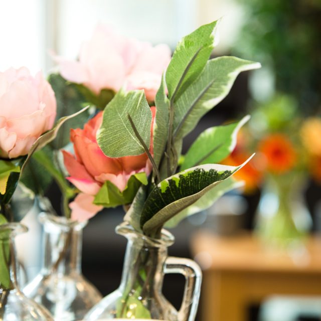 Orange flowers and green foliage in a vase.