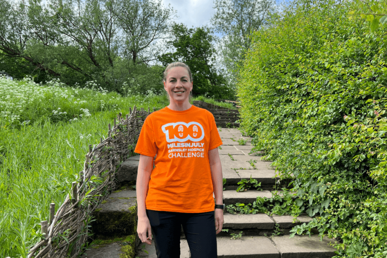Photo of woman wearing a t-shirt promoting the 100 miles in July Barnsley Hospice challenge