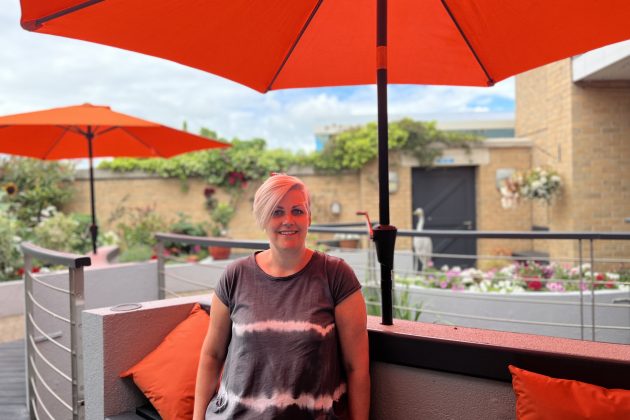 Caroline sat in the hospice garden underneath orange parasol