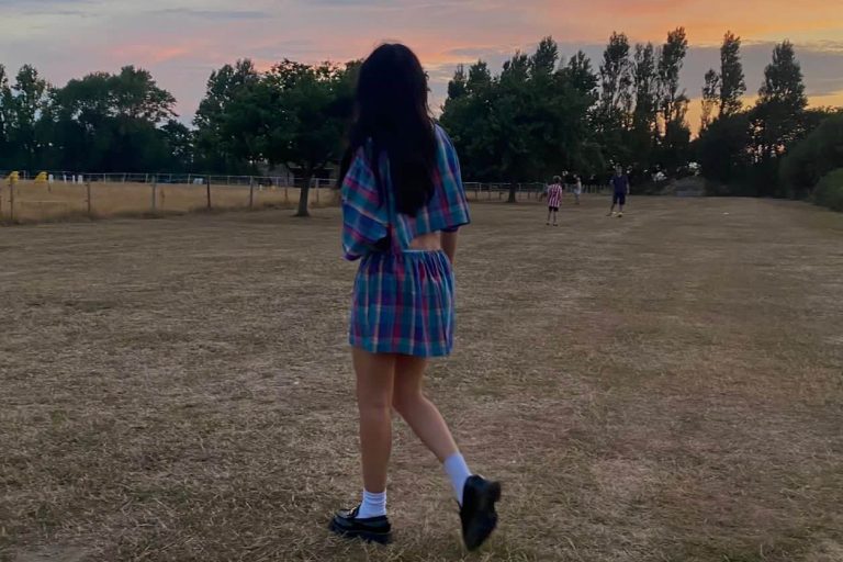 Young woman wearing transformed outfit standing in a field