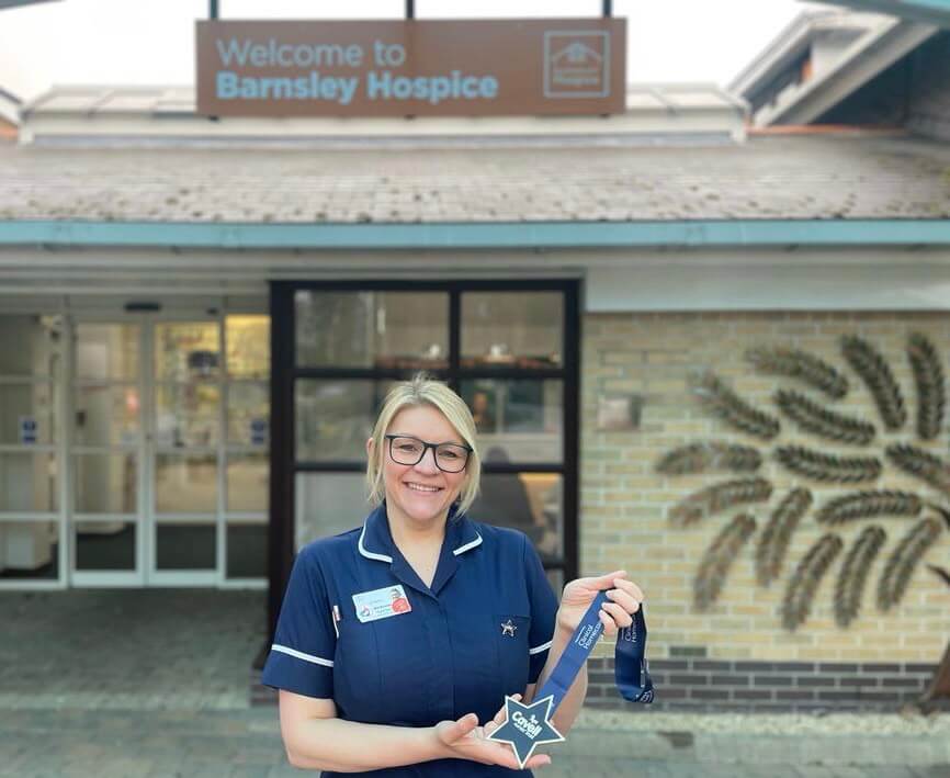 Mel Butcher with her Cavell Star award outside the hospice entrance