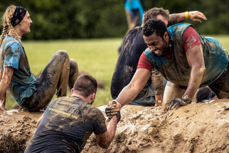 groups of adults taking part in a tough mudder