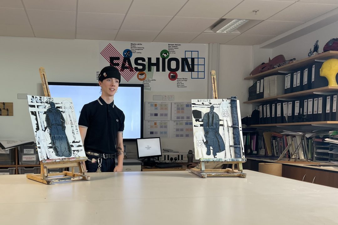 fashion student with design boards in classroom