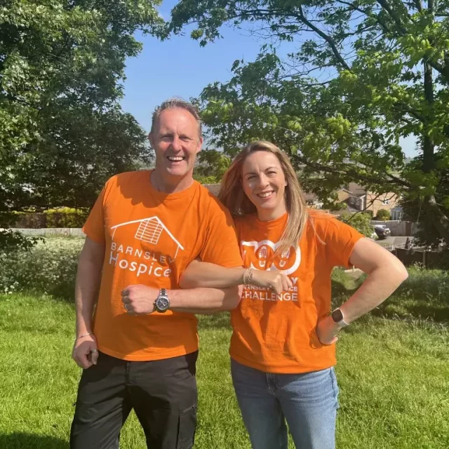 Couple wearing hospice t-shirts linking arms
